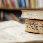 A close-up of old math books and handwritten notes with formulas, resting on a library desk